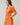 Model wearing the Donna Dot Elanie Button Down Mini Dress in orange pink with pockets and short sleeves.