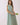 Model wearing Striped Smocked Waist Round Neck Midi Dress holding tulips, showcasing its striped pattern and relaxed fit.