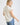 Back view of a woman wearing COLLARED V NECK BUTTON DOWN LINE LACE SHIRT, highlighting the relaxed fit and short sleeves.