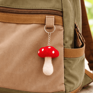Felt Mushroom Keychain Bag Charm attached to a backpack, showcasing a colorful handmade design.