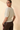 Back view of model wearing cream ribbed knit top with brown pants