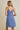 Model wearing SURPLICE S.P.G STRAP FALRE HEM DITSY MINI DRESS from the back, showcasing its floral design.