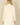 Back view of a woman wearing a Shop Wall cream long sleeve open front cardigan with a smooth knit texture