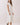 Model showcasing the Classic Shirt Collar Neck Pleated Detail Dress in white, featuring a shirt collar and pleated hem.