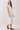Model showcasing the Classic Shirt Collar Neck Pleated Detail Dress in white, featuring a shirt collar and pleated hem.