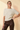 Front view of model wearing cream ribbed knit top with brown pants