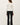 Back view of model wearing white long sleeve top with black pants