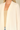 Shop Wall cream open front long sleeve cardigan with a smooth knit texture worn over a beige tank top