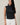 Model wearing HIGH NECK EXTENDED SHOULDER SIDE RUCHED POLKA DOT TOP with white jeans, showcasing a stylish, modern, vintage-inspired look.