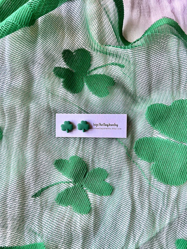 Shamrock Clay Studs Shamrock Stud Earrings displayed on a green background with clover designs.