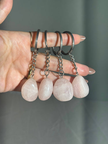 Rose Quartz Crystal Keychain featuring polished pale pink gemstones on a dark green background