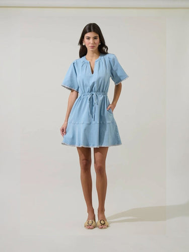 Model wearing Gabriella Denim Fray Mini Dress in light denim, front view