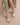 The Andrea Natural Bow Raffia Slide Feminine Summer Flat worn with a polka dot dress, showcasing a stylish summer look.