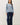 Full-length view of model wearing blue raglan sleeve pullover sweater with jeans