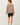 Back view of model wearing stone cotton modal fleece sweatshirt with black shorts