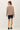 Back view of model wearing stone cotton modal fleece sweatshirt with black shorts