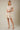 Shop Wall beige striped mini dress with notch neck, short sleeves, and smocked waist on a blonde model