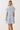 Back view of a woman wearing a Printed Notch Neckline Tiered Mini Dress with short flutter sleeves.