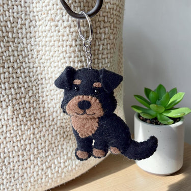 Rottweiler Puppy Dog Felt Wool Keychain hanging from a textured bag