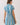 Back view of a woman wearing a Blue Stripe Button Down Shirt Mini Dress with short sleeves and cinched waist.