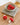 Felt Mushroom Keychain Bag Charm collection displayed in a bowl on a textured mat, showcasing their vibrant colors.