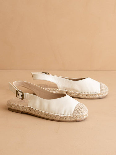 The Massa White Ballet Inspired Espadrille Flat with jute details and a sleek design on a beige background.