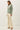 Side view of model wearing green slub pullover sweater with cream pants