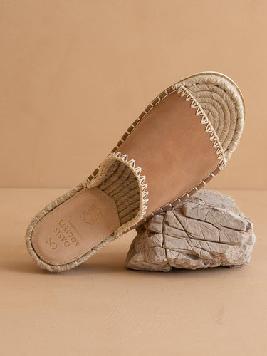 The Vista Camel Espadrille Platform Sandal displayed on a rock, highlighting its vegan leather upper and espadrille detailing.