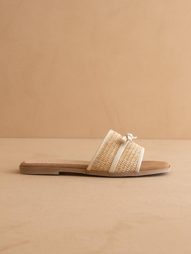 The Andrea Natural Bow Raffia Slide Feminine Summer Flat showcasing raffia woven strap and bow accent.