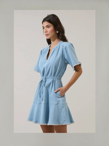 Gabriella Denim Fray Mini Dress styled with fringe details and cinched tie-waist, in lt denim color, featuring short sleeves and pockets.