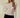 Boat neck semi bell long sleeve knit top in beige worn by model, showcasing a fitted silhouette and elegant design.