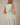 Back view of model in V NECK BUTTON UP SLEEVELESS PRINT DRESS featuring a green zebra print.