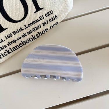 Sweet Striped Acrylic Hair Claw in light colors on a wooden surface.