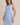 Light blue boat neck sleeveless side tie mini dress worn by a model, front view.