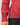 Close-up view of model wearing red raglan sleeve pullover sweater with black pants