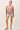 Full-length view of model wearing pink long sleeve top with denim shorts