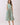 Striped Smocked Waist Round Neck Midi Dress on model, featuring a round neckline, sleeveless design, and side pockets.