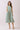 Striped Smocked Waist Round Neck Midi Dress on model, featuring a round neckline, sleeveless design, and side pockets.
