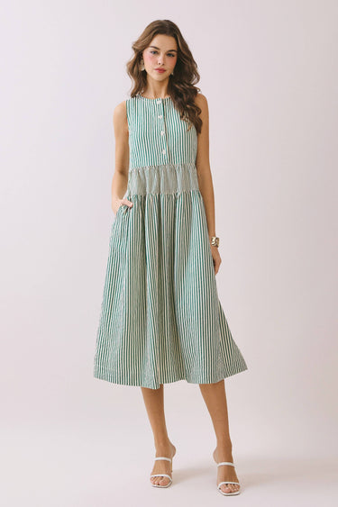 Striped Smocked Waist Round Neck Midi Dress on model, featuring a round neckline, sleeveless design, and side pockets.