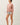 Side view of model wearing pink long sleeve top with denim shorts