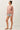 Side view of model wearing pink long sleeve top with denim shorts