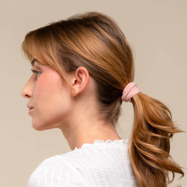 Recycled Fabric Hair Elastics in a blush color used in a ponytail hairstyle on a woman with long hair.