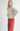 Front three-quarter view of model wearing Irisha oatmeal diamond pointelle sweater with red pants