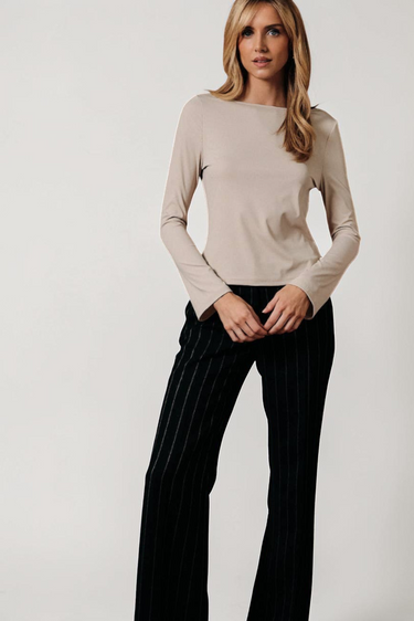 Full-length view of model wearing white Boat Neck Semi Bell Long Sleeve Knit Top with black pants