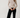 Full-length view of model wearing white Boat Neck Semi Bell Long Sleeve Knit Top with black pants