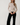 Full-length view of model wearing white Boat Neck Semi Bell Long Sleeve Knit Top with black pants