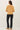 Back view of model wearing yellow button-up cardigan with black pants