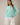 Model wearing mint green Round Rolled Hemline Detail Thin Sweater Cardigan with white pants