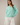 Model wearing mint green Round Rolled Hemline Detail Thin Sweater Cardigan with white pants