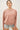 Model wearing pink long sleeve top with denim shorts